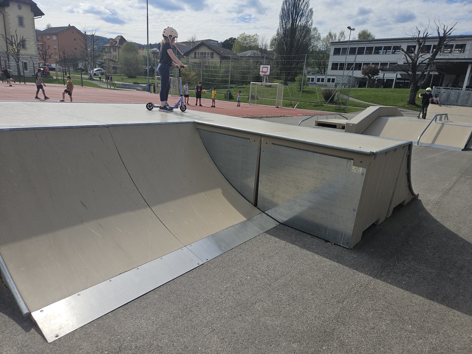 Quarter-pipe en béton utilisé par une pratiquante casquée